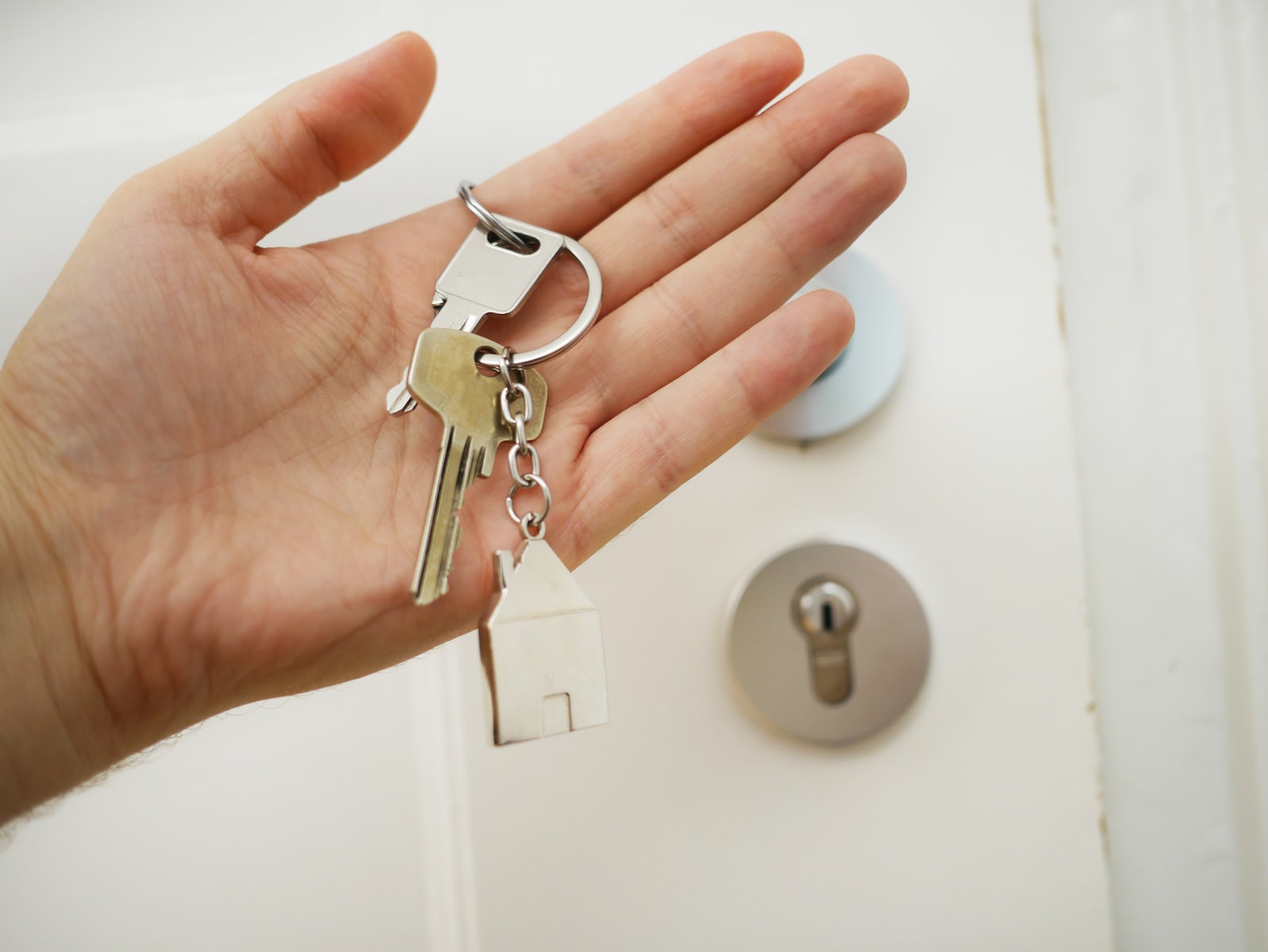 Keys in a person's hand in front of a locked door