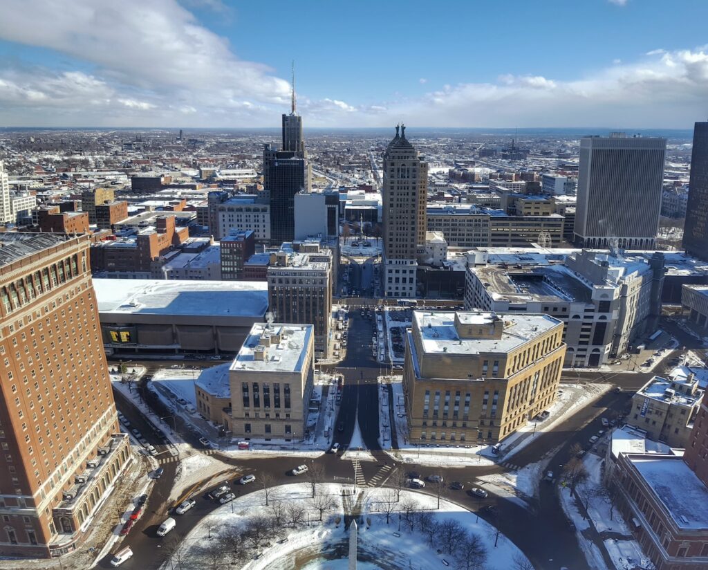 Buildings in Buffalo, NY with snow on the ground against a blue sky in the daytime