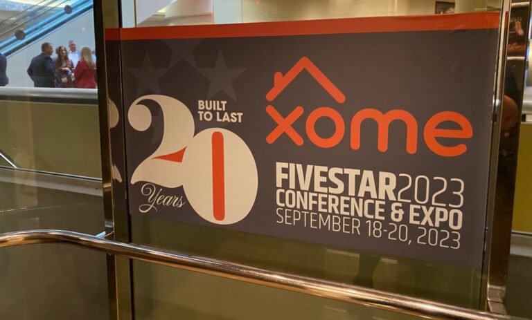Photo of sign on glass window advertising Xome sponsoring the 2023 Five Star conference and expo